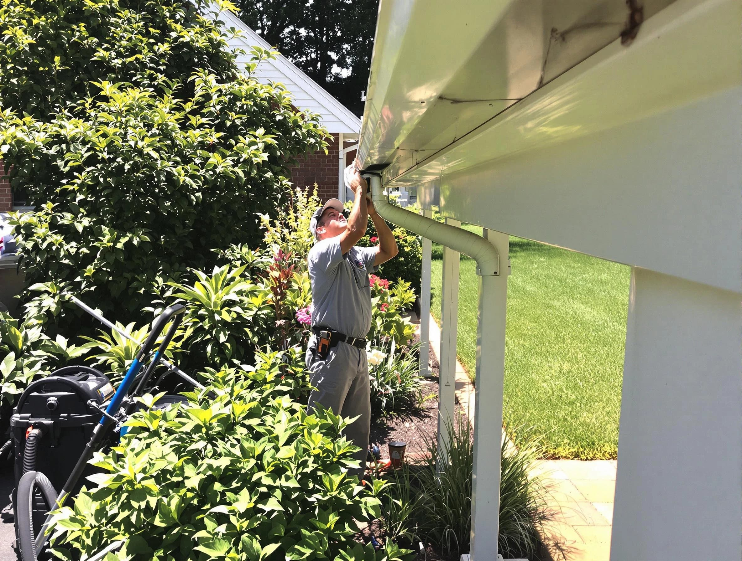 Technician flushing a blockage from a downspout in Parma Heights, OH